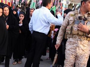 Iranian Shiite Muslim pilgrims walk past a member of Iraq's security personnel in Kerbala, 110 km south of Baghdad, June 7, 2013. (Reuters)