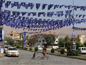 A Kurd young boy cross a street under blue flags, emblazoned with a candle, of the Movement for Change (MC) (aka Goran) displayed in the streets as part of the campaign for Kurdistan's parliamentary elections on September 18, 2013 in Iraq's northern city of Sulaimaniyah. (AFP)
