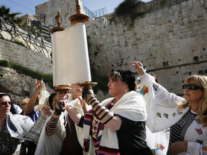 Although allowing women to hold Torah scrolls isn't too common in the Orthodox community, it is not prohibited. [Illustrative photo: Members of Women of the Wall wear prayer shawls as they read from the Torah and pray at Robinson's Arch, near the Western Wall in Jerusalem earlier this year (photo credit: Miriam Alster/Flash90)]