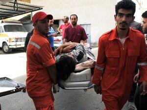 Lebanese Red Cross volunteers use a stretcher to move a Syrian, who was wounded in the nearby Syrian city of Qusair, from an ambulance upon their arrival at an hospital on Saturday. AFP Photo