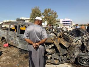 Benghazi residents gather at the site of a car blast in the parking lot of school used as an electoral office on October 26, 2013. On Sunday night, a Libyan intelligence officer and his two-year old son were killed in a car bomb attack. (AFP)
