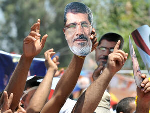 Supporters of deposed president Mohamed Morsi (portrait) shout slogans during a demonstration following Friday prayers in Cairo on July 26, 2013 (AFP)