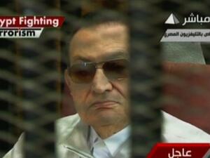 An image grab taken from the Egyptian state TV shows Egypt's ousted dictator Hosni Mubarak sitting in the defendants' cage on August 25, 2013 during his trial in Cairo. (AFP/Egyptian TV)