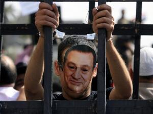 A critic of former Egyptian president Mubarak is seen wearing a mask of his face in Cairo. (AFP/File)