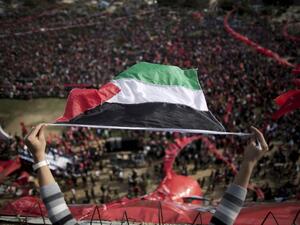 GAZA CITY : A Palestinian youth waves a national flag during a rally in Gaza City on December 7, 2013, marking the 46th anniversary of the founding of the Popular Front for the Liberation of Palestine (PFLP), a Palestinian Marxist revolutionary organization established in 1967. (AFP)