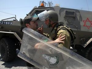 An Israeli soldier wags his finger at a Palestinian protester is seized by an during the evacuation of Palestinian protesters as they were trying to close the main road leading to the Israeli settlment of Efrata in the West bank town of Bethlehem on August 16, 2013 (AFP)