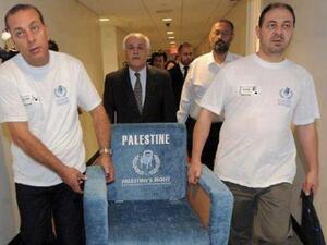 Members of the Palestinian delegation to the UN carry a chair similar to those used in the UN General Assembly.