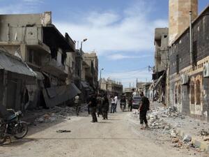 Syrian army soldiers assess a damaged street in the town of Qusair, in Syria's central Homs province on  Friday, as the regime sought to 'remove' all remaining rebel strongholds in the country. AFP 