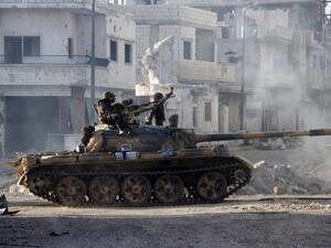 Syrian army troops drive through the ravaged streets of Qusayr in the central Homs province on Wednesday. AFP Photo