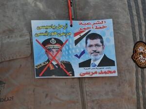 A sticker shows ousted president Mohamed Morsi (R) and army chief Abdel Fattah al-Sisi, in Cairo, July 24, 2013 (AFP)