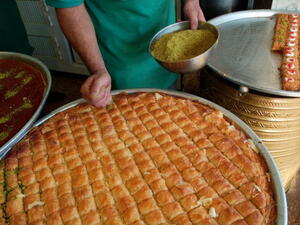 A Jordanian pastry chef puts crushed pistachio nuts on patries on the first day of the Muslim holiday of Eid al-Fitr in Amman. (Getty)
