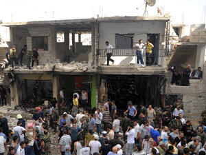A handout picture released by the Syrian Arab News Agency (SANA) on June 23, 2013, shows civilians and security at the scene of a bombing in the Mazzeh 86 area of the Syrian capital Damascus. (Source: AFP/SANA)
