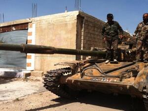 Syrian army soldiers standing on an army tank in the village of Buweida, north of Qusayr, in Syria's central Homs province on Friday. AFP photo