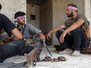 Rebel fighters sit in the ruins of a building in Aleppo earlier this week. Assad's army is making moves on the northern province, a rebel bastion. AFP/Shams photo