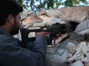  A Syrian rebel fighter points his riffle through a hole in sandbags as he holds a position in a trench, 100m far from the regime-controlled military base in Idlib province. AFP photo