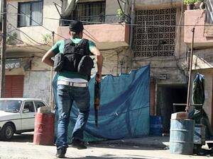 A gunman carries a rifle as he runs in Tabbaneh area in Tripoli, Tuesday, Oct. 22, 2013. (The Daily Star/Antoine Amrieh)