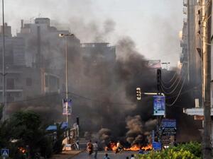 Black smoke acsends from burning tires laid across a street in the northern city of Tripoli on Sunday. (AFP)
