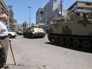 A man looks at tanks of Lebanese Army Forces patrolling on June 6, 2013 in a street of the eastern Lebanese city of Tripoli. AFP Photo