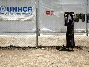 A woman put clothes to dry on a line at a Syrian refugee camp. AFP Photo
