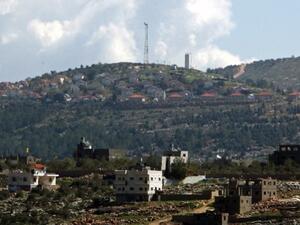 The general view of the Jewish settlement of Itamar (background) behind the West Bank village of Awarta. Israeli settlers are seeking approval for hundreds of homes in the northern West Bank. AFP photo
