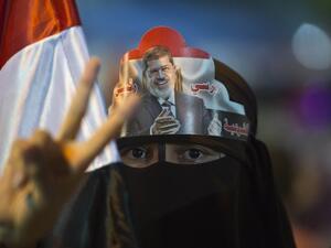 A female supporter puts Egypt's deposed president Mohamed Morsi portrait on her head during sit in outside Rabaa al-Adawiya mosque in Cairo on August 1, 2013. (AFP)