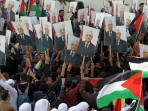 فلسطينيون يرفعون صورا للرئيس الفلسطيني محمود عباس في رام الله
