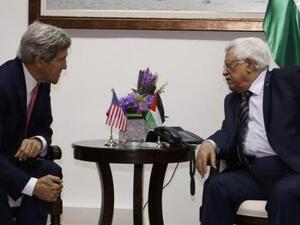 عباس (الى اليمين) ينصت الى كيري أثناء اجتماعهما في رام الله بالضفة الغربية يوم الخميس
