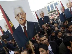 فلسطينيون يحملون صورا للرئيس الفلسطيني محمود عباس في رام الله
