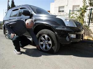 رجل يفحص اطار سيارته في قرية ابو غوش بالقرب من القدس
