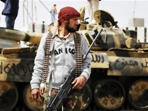 معارض مسلح أمام دبابة تخلت عنها قوات القذافي قرب اجدابيا
