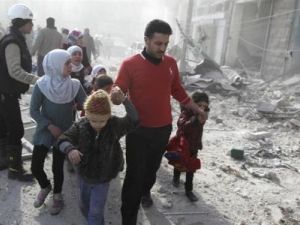 شخص يقود بعض الاطفال من منطقة مدمرة في حلب
