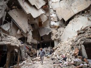 A Syrian man walks amid destruction in the northern Syrian city of Aleppo on Wednesday. (Photo:  AFP / DIMITAR DILKOFF) 