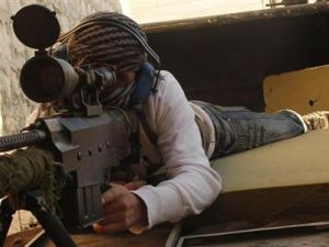 مقاتل من الجيش السوري الحر يصوب سلاحه وهو يتحصن في وضع دفاعي بقرية في ريف حلب
