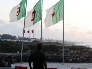 جندي جزائري يقف تحت اعلام لبلاده
