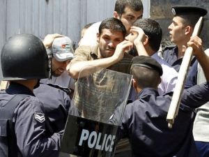 عناصر من الشرطة الاردنية يعتقلون متظاهرا في عمان
