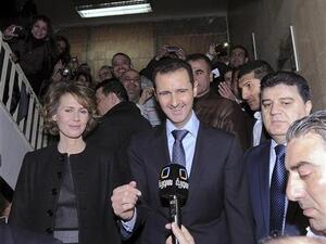 الرئيس السوري بشار الاسد وزوجته امام وسائل الاعلام بعد المشاركة في التصويت بمبنى تابع للتلفزيون السوري في دمشق يوم الاحد
