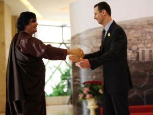 Both leaders Al-Assad and Gaddafi have seen better times. Here, they meet and greet at the Arab Summit at Damascus, 2008.