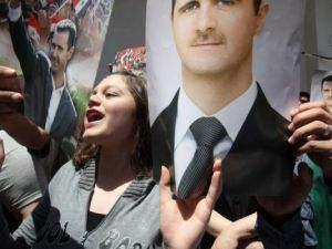 مؤيدون للاسد يرفعون صوره قبل الادلاء باصواتهم في دمشق
