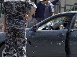 شرطي عراقي يتفحص سيارة اصيبت باضرار في انفجار في بغداد
