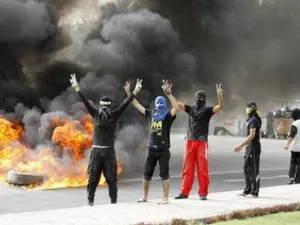 محتجون يشيرون بعلامة النصر في حي البديع يوم الأحد
