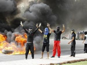 محتجون يشيرون بعلامة النصر في حي البديع يوم الأحد
