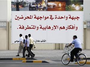 رجال يمرون امام لافتة نصبها احد نواب البرلمان في المنامة