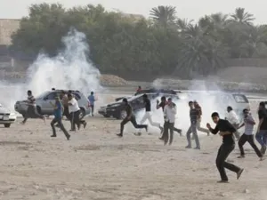 محتجون مناهضون للحكومة يفرون للاحتماء من قنابل غاز خلال مظاهرة شرقي المنامة يوم 15 يونيو حزيران 2012
