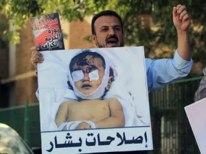 متظاهر يرفع صورة طفل قتلته القوات السورية خلال تظاهرة قام بها سوريون وسودانيون في الخرطوم للتنديد بالقمع في سوريا