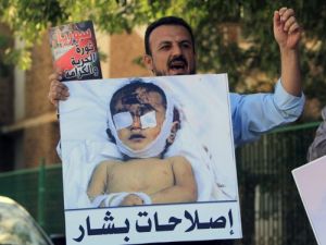 متظاهر يرفع صورة طفل قتلته القوات السورية خلال تظاهرة قام بها سوريون وسودانيون في الخرطوم للتنديد بالقمع في سوريا