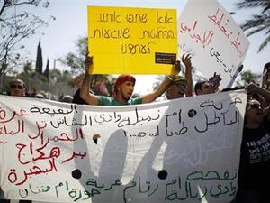 محتجون يرفعون لافتات أثناء مظاهرة في بئر السبع جنوب اسرائيل يوم الاثنين تضامنا مع بدو النقب الذين تريد الحكومة الاسرائيلية مصادرة أراضيهم
