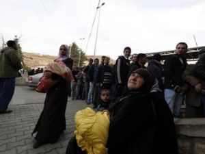 
فلسطينيات ممن كن يقمن في مخيم اليرموك بسوريا ينتظرن بينما يقف الرجال في طابور لختم وثائق دخولهم الى لبنان عند نقطة المصنع الحدودية بين سوريا ولبنان يوم الثلاثاء