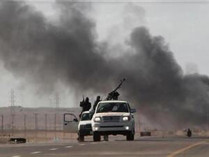 ثوار مسلحون مناهضون للزعيم الليبي معمر القذافي ينسحبون بعد قصف مدفعي من قبل القوات الموالية له في منطقة بن جواد يوم الاحد. 