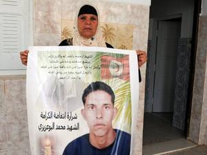 والدة محمد بوعزيزي الذي شكل شرارة الثورة في تونس تحمل صورته
