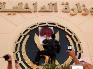 محتج يلصق رسما على شعار وزارة الداخلية خارج مبنى الوزارة بالقاهرة 
